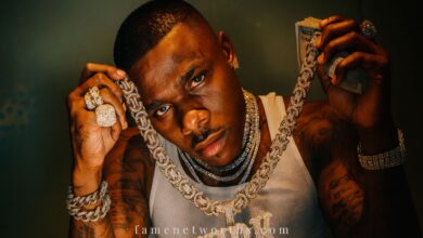 DaBaby showing his diamond "KIRK" chain, luxury jewelry, and cash for net worth 2025 banner image.